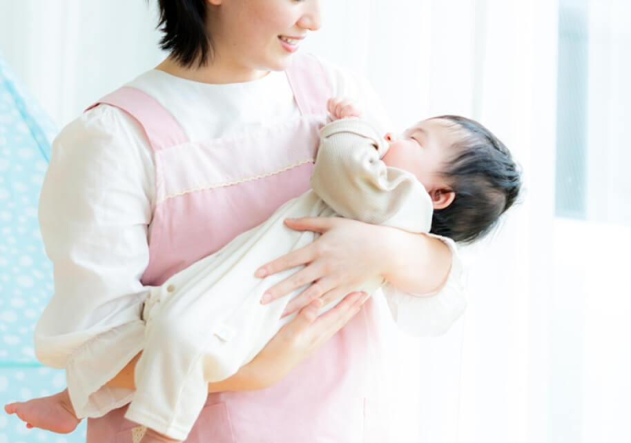 赤ちゃんを優しく抱く保育スタッフ