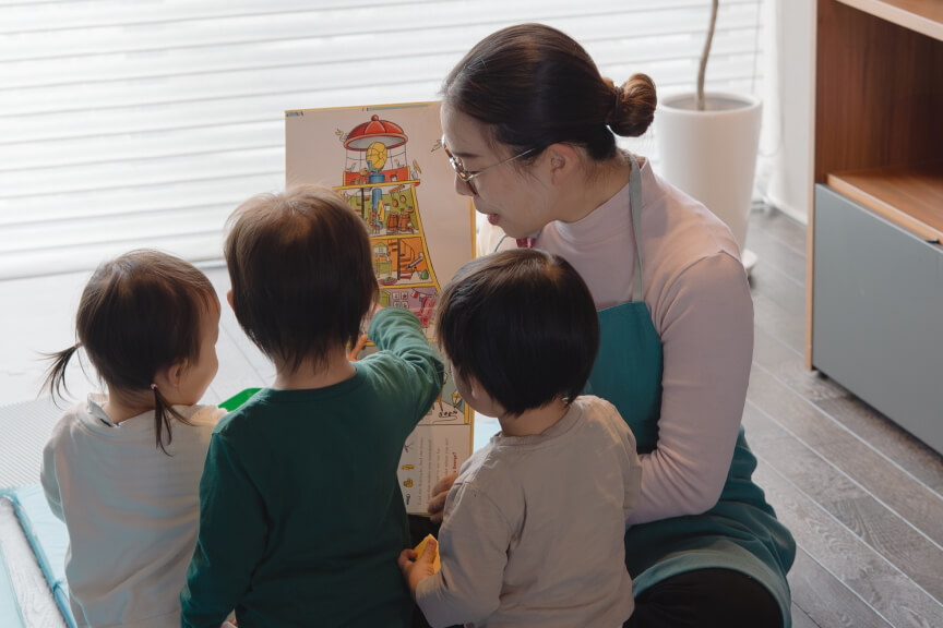 NAOMIが幼児たちに絵本を見せて遊ぶ